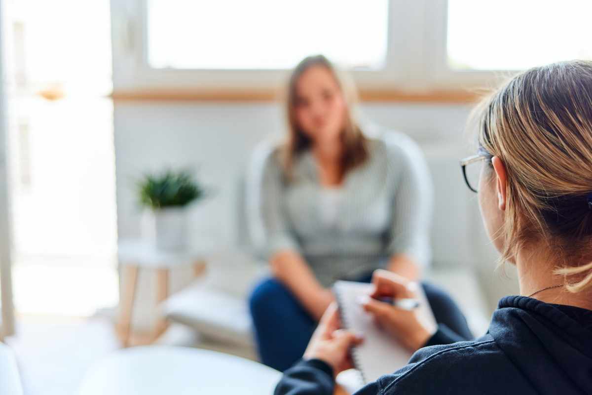 Therapist explaining stages in autism assessment to patient in a clinical setting